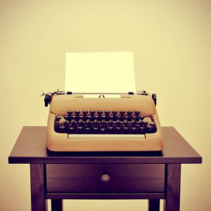 an old typewriter with a blank page on a desk, with a retro effect